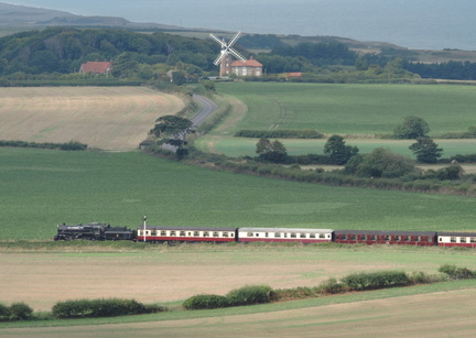 Steam train in front of windmill