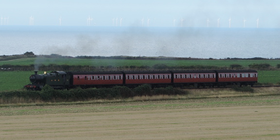 Steam train in front of turbines